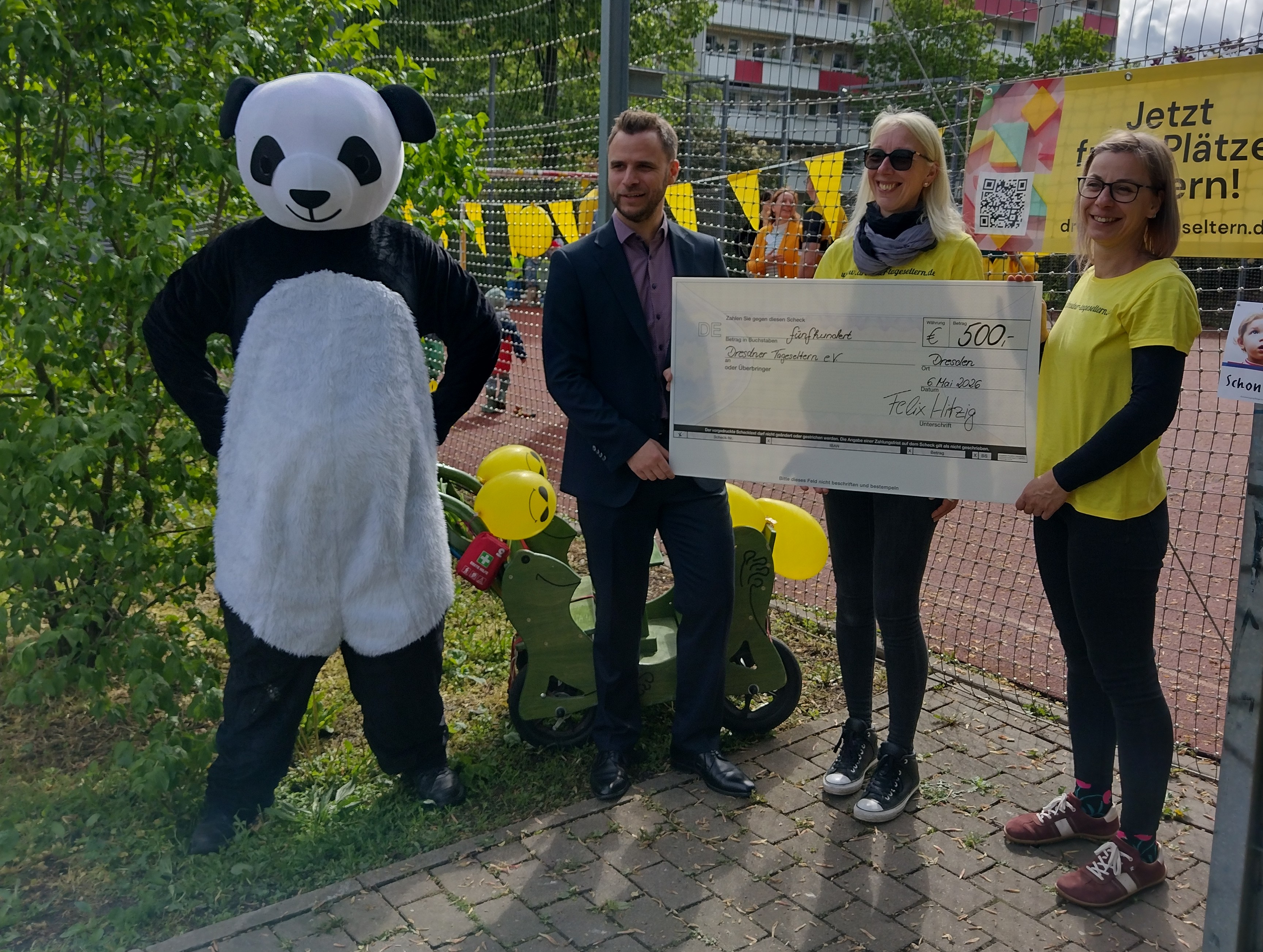 Felix Hitzig überreicht dem Dresdner Tageselternverein eine Spende.