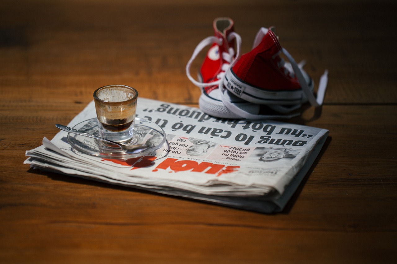 Symbolfoto: Zeitung, Espresso und Kinderschuhe