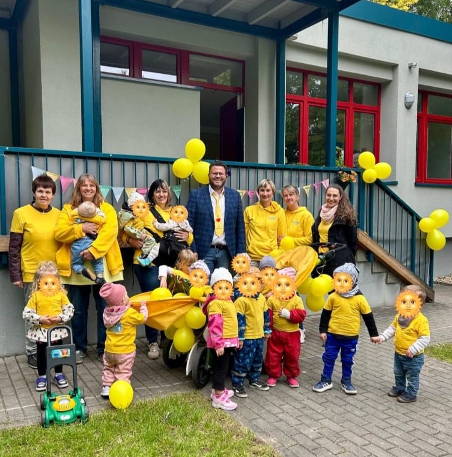 Hohenstein-Ernstthaler Tagesmütter und ihre Kinder, der Bürgermeister Lars Kluge sowie Sophie Güttler von der IKS vor dem Stützpunkthaus.